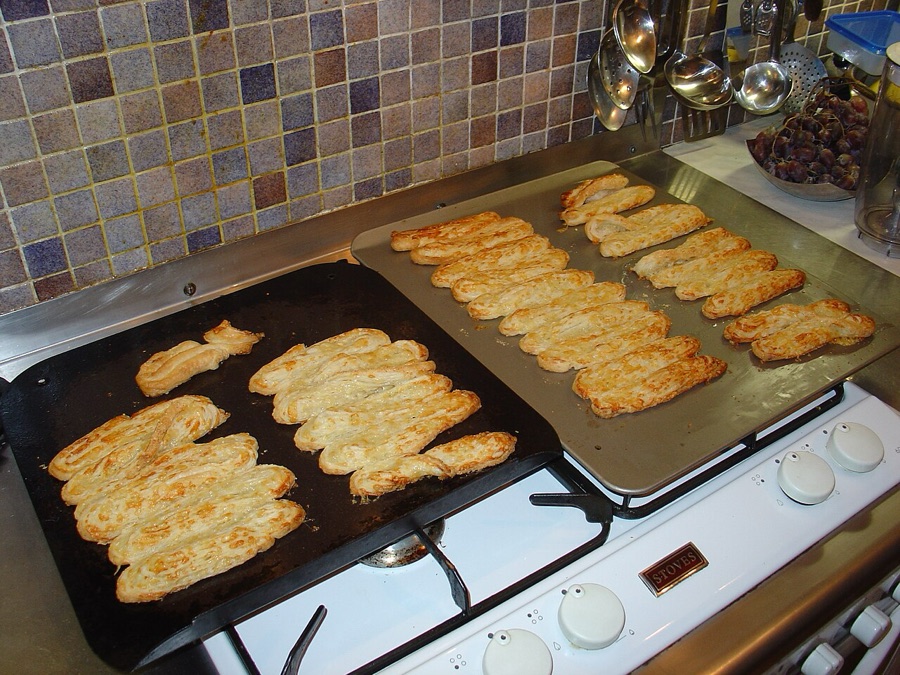 Home-baked cheese straws cooling on trays