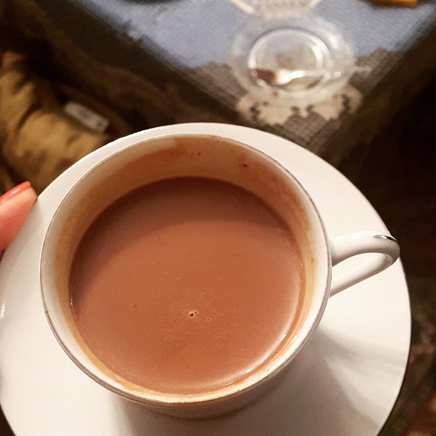 Cocoa tea, creamy and dark in a white cup