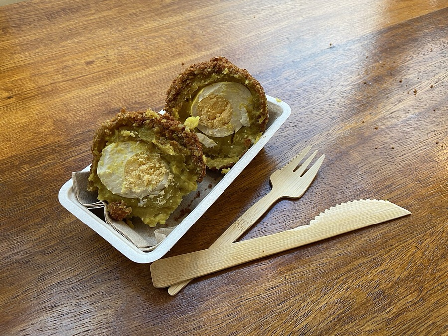 Egg ball cut open showing the boiled egg in its golden coat