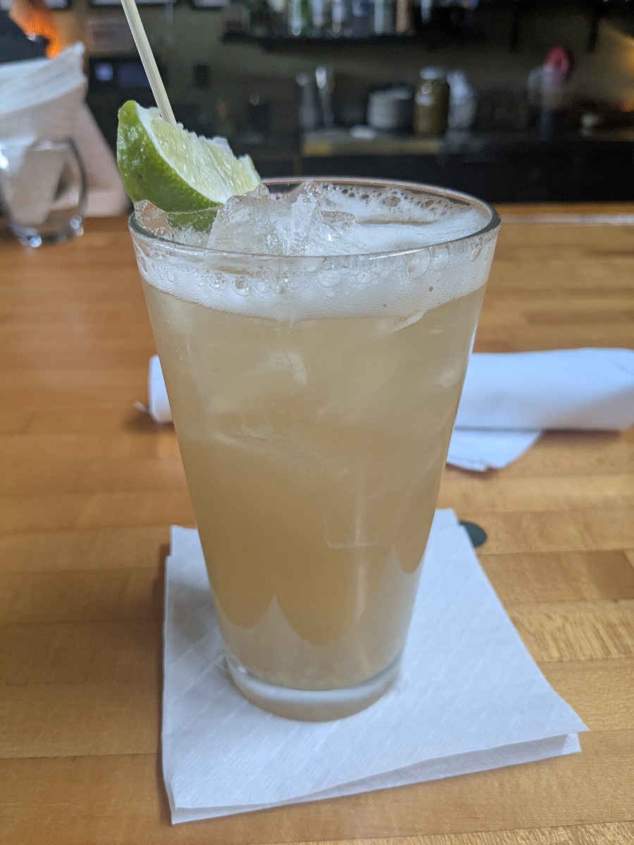 Fresh ginger beer over ice with a lime wedge