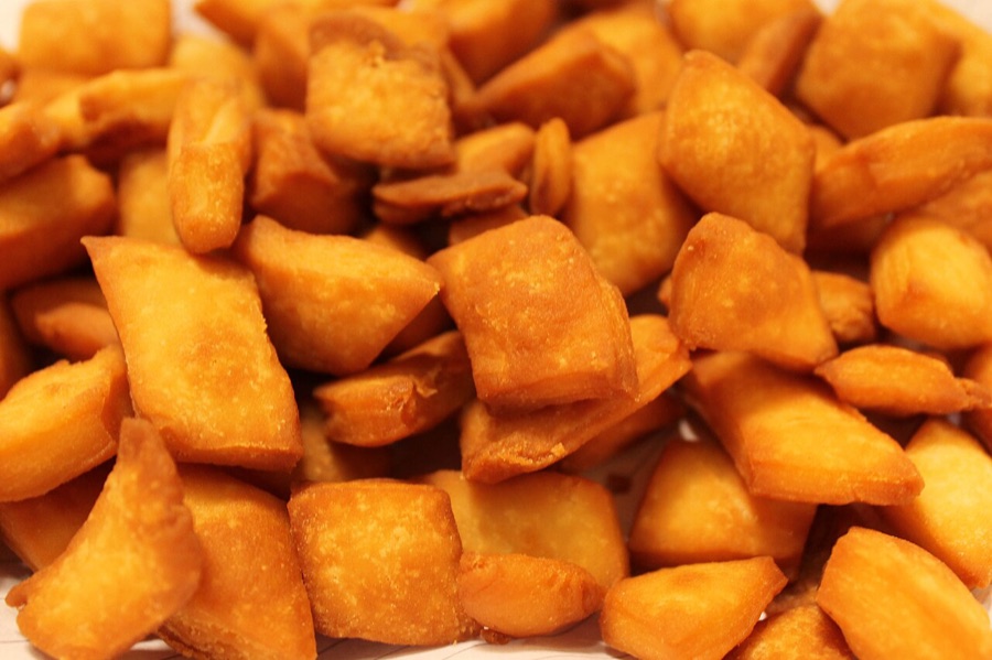 Golden fried kurma pieces piled high