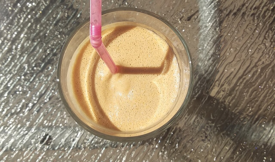 Creamy peanut punch with a pink straw